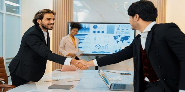 Successful businesspeople shaking hands while making agreement ornamented