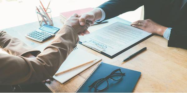 Cropped image of businessman shaking hands with male colleague in office