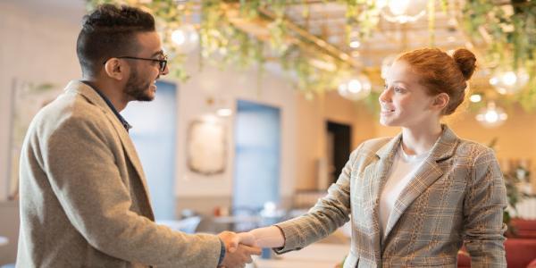 A man and a woman talking and shaking hands