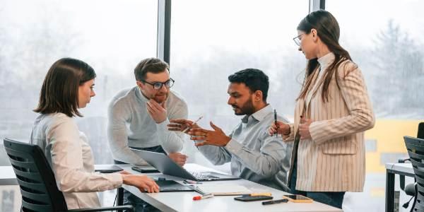 Having meeting four people are working in the office together
