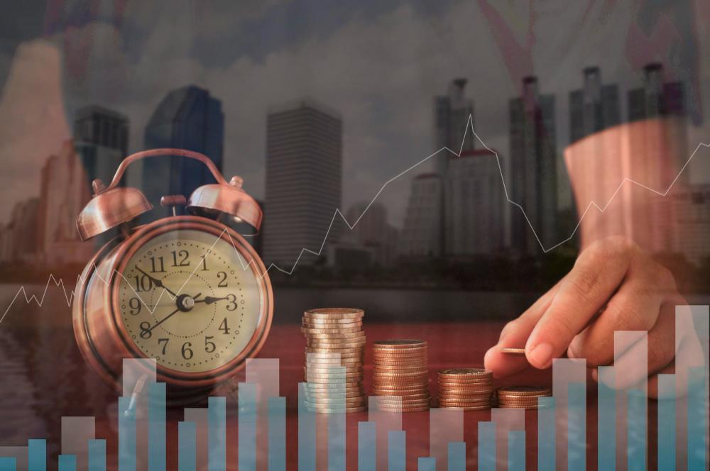 Close-up of hand holding clock on table