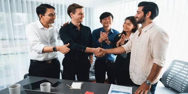 Diverse group of business people shake hand after making agreement