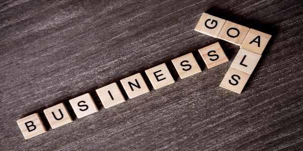 Above shot of wooden text business goals on table