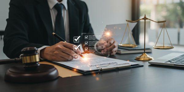 Legal professional reviewing contract documents with scales of justice and gavel