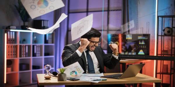 Bearded businessman in suit getting bad news looking on laptop screen