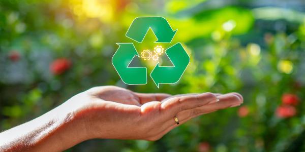 Close up of hand holding green recycle symbol recycle concept
