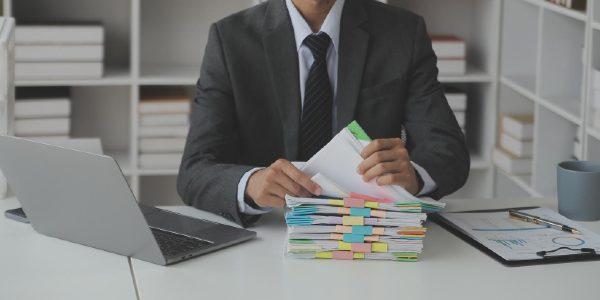 Businessman looking at documents and reports on table