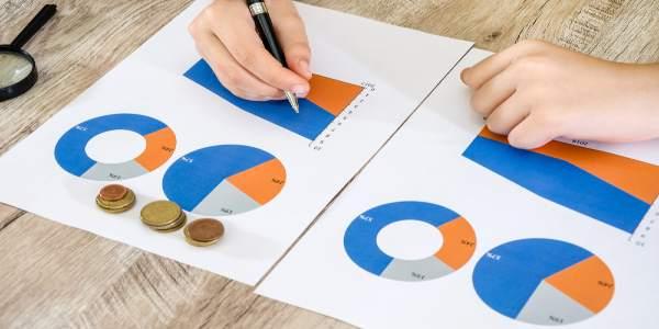 Hands with a pen on the background of business charts