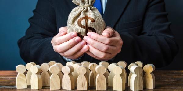 Businessman holds dollar money bag paying salaries and grants staff maintenance financial support