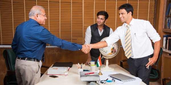 Business people working in office shaking hands to close a deal