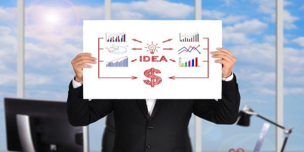 A man in suit holding a white board with business graphs, dollar and idea on it