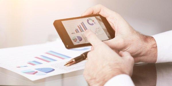 Man using mobile smart phone and checking graphs