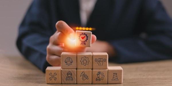 Handholding representation of certification icons symbolising quality assurance compliance