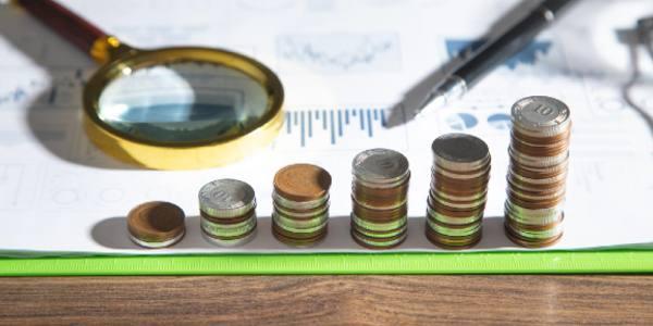 Stack of coins on financial graphs